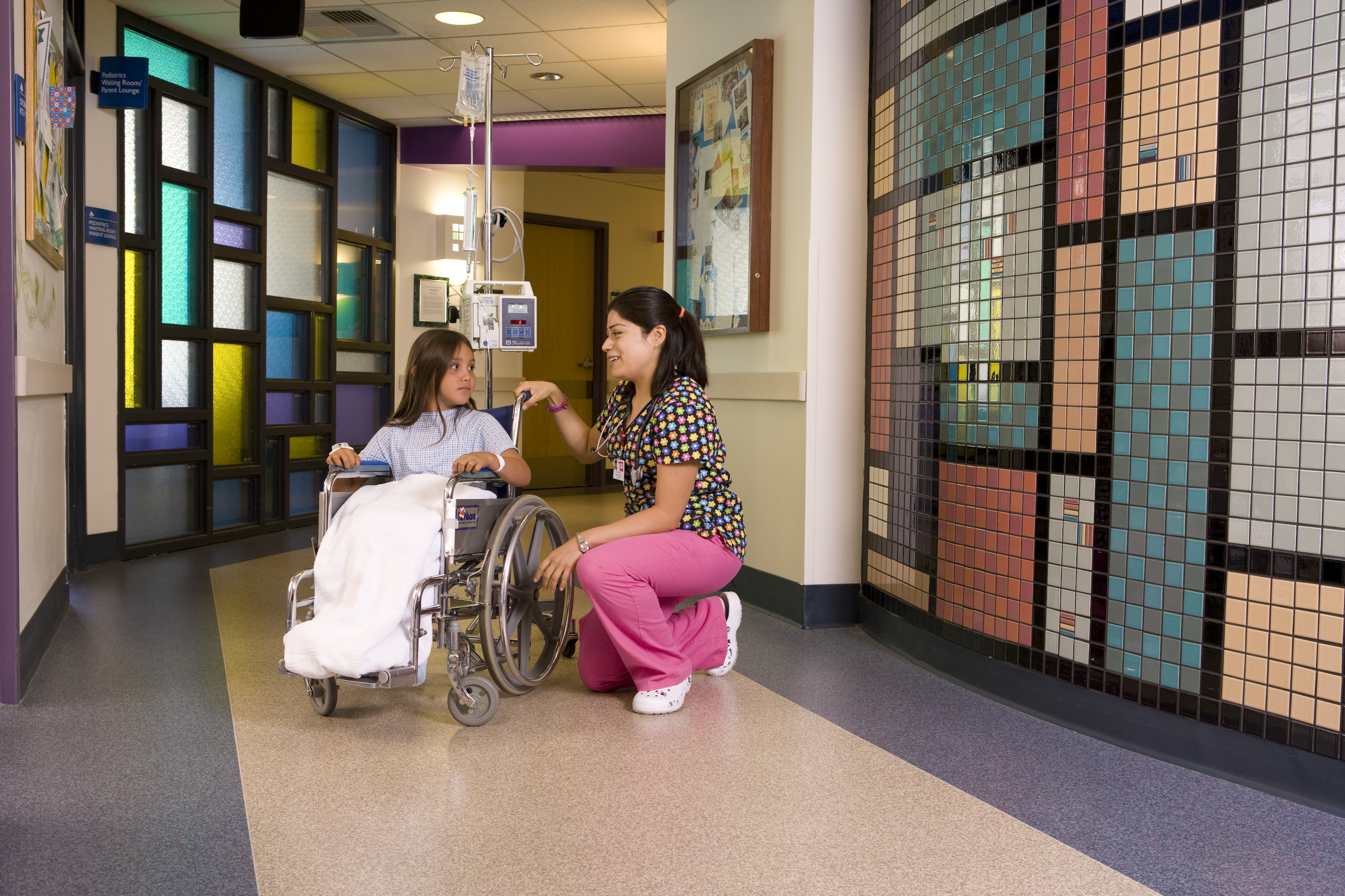 Young Girl in Wheelchair with Nurse Kneeling By Her
