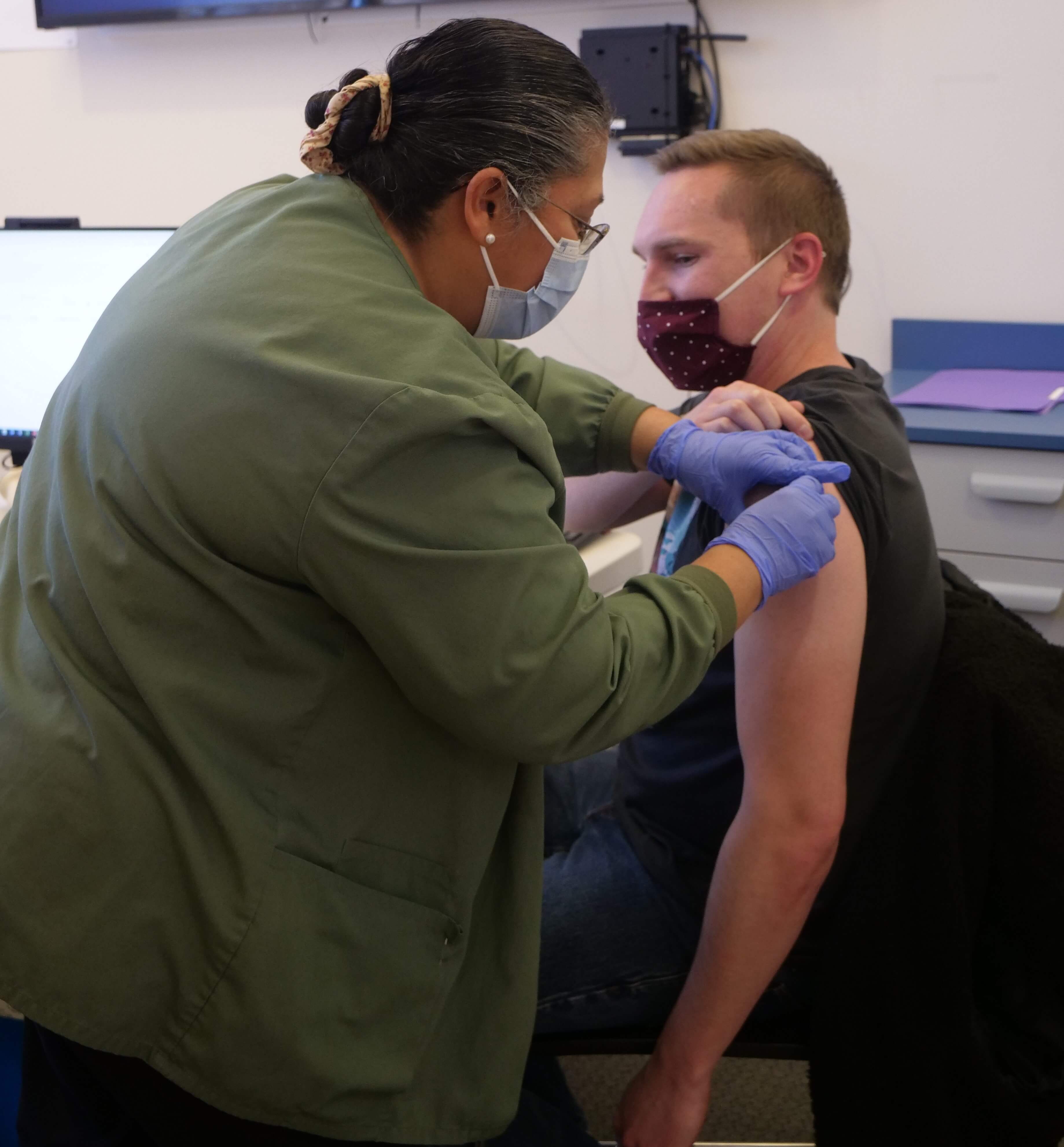 Nurse vaccinates man's arm
