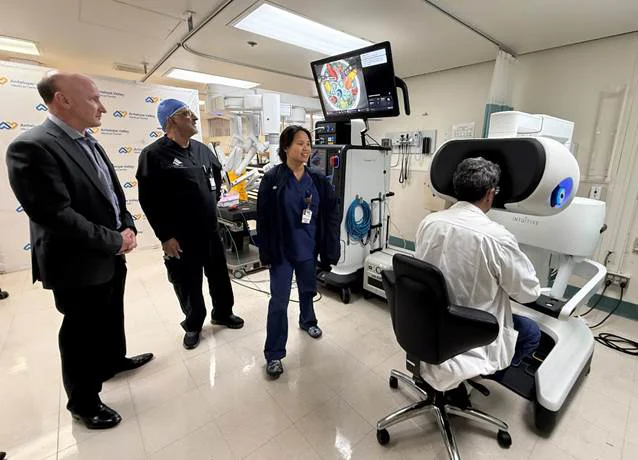 doctors standing around a machine
