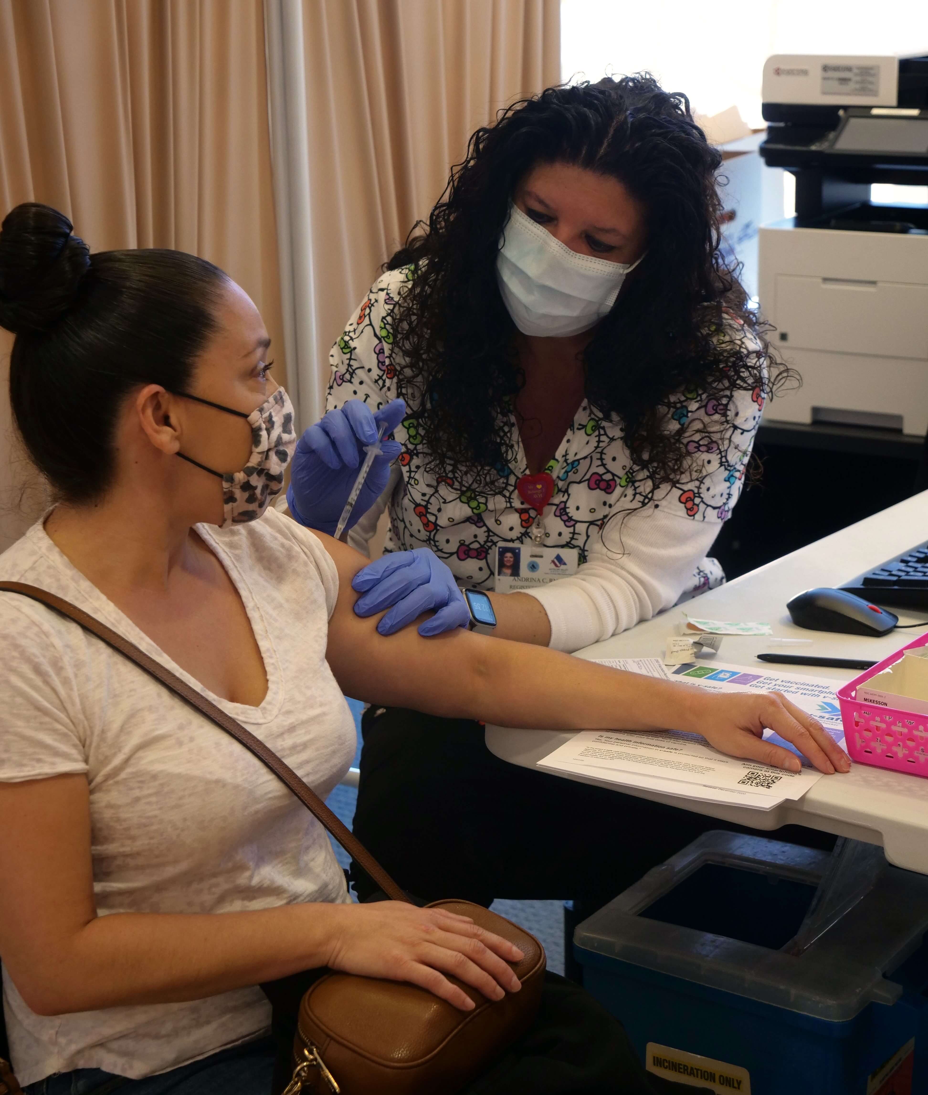 Nurse vaccinates woman's arm