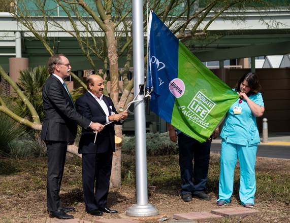 CEO and Jessica Horton hanging up flag