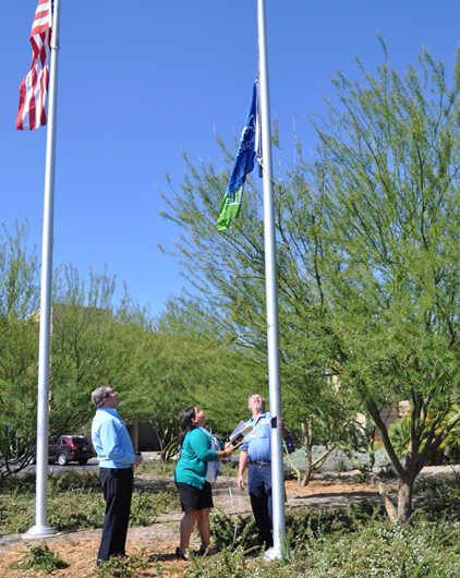 Mike Wall and Angela Bolaris raising flag